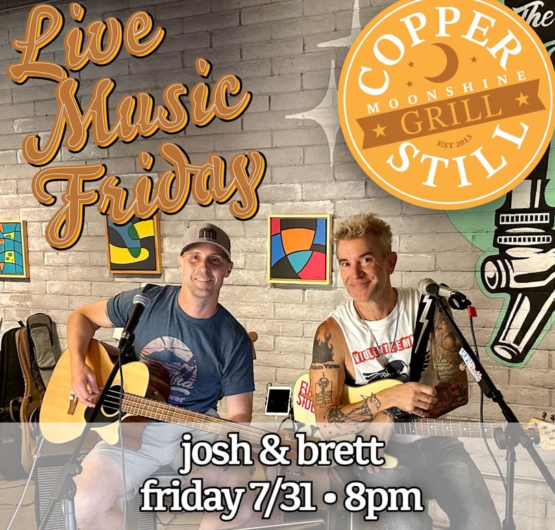Two men playing guitars and singing at Copper Moonshine Grill Still for Live Music Fridays.